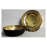 A TIBETAN BRONZE CIRCULAR SOUNDING BOWL, 10ins diameter, and a PLATE (2).