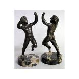 TWO 19TH CENTURY BRONZED ROMANESQUE CUPIDS on circular marble bases. 7ins high.