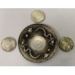 A CHINESE SILVER-METAL COIN DISH, 3.9in diameter; together with three Chinese silver-metal coins,