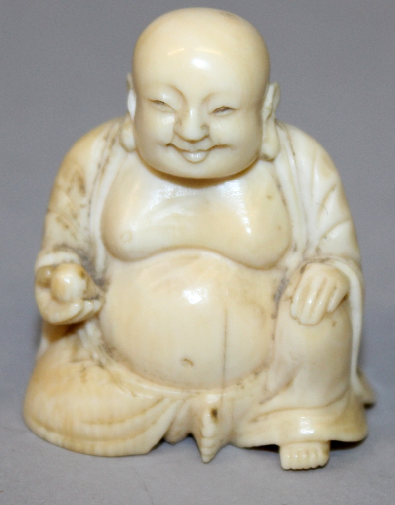 A SMALL 19TH CENTURY CHINESE CARVED IVORY FIGURE OF BUDAI, seated with cheerful expression, 1.75in