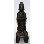 A 17TH CENTURY CHINESE BRONZE FIGURE OF AN OFFICIAL, bearing a scroll and standing on a