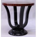 AN ART DECO STYLE ROSEWOOD AND EBONISED TABLE, the circular top supported on curving legs. 2ft