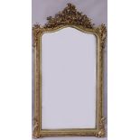 A 19TH CENTURY GILT FRAMED MIRROR, with curving top and ormolu gesso applied decoration. 5ft 0ins