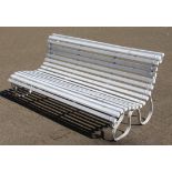 A GOOD WROUGHT IRON AND WOODEN SLATTED WHITE PAINTED GARDEN BENCH of scrolling design.