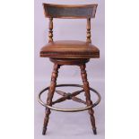 A MAHOGANY BAR STOOL, with upholstered swivel seat, on turned and reeded legs with brass footrest.