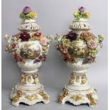 A LARGE PAIR OF "DRESDEN" STYLE FLOWER ENCRUSTED URNS, COVERS AND STANDS, with scenes of young