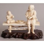 A GOOD QUALITY SIGNED JAPANESE MEIJI PERIOD SECTIONAL IVORY OKIMONO OF AN ELDERLY MAN & A BOY,