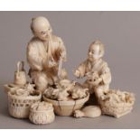 AN UNUSUAL FINE QUALITY JAPANESE MEIJI PERIOD IVORY OKIMONO OF A SHELL SELLER & HIS SON, seated