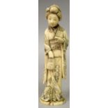 A SIGNED JAPANESE MEIJI PERIOD IVORY OKIMONO OF A BIJIN, standing in engraved robes and holding a