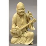 A JAPANESE MEIJI PERIOD IVORY OKIMONO OF GAMMA SENNIN, kneeling and playing a samisen and in the