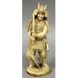 A GOOD QUALITY JAPANESE MEIJI PERIOD IVORY OKIMONO OF A SAMURAI, standing in armour and bearing an