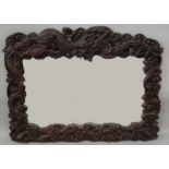 A LARGE & ELABORATELY CARVED JAPANESE MEIJI PERIOD HARDWOOD FRAMED MIRROR, the frame well carved and