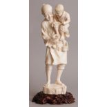 A LARGE FINE QUALITY SIGNED JAPANESE TOKYO SCHOOL IVORY OKIMONO OF A STANDING MAN WITH HIS SON,