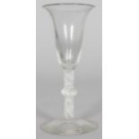 A GEORGIAN WINE GLASS with inverted bell bowl, white opaque twist stem and single knop. 6ins high.