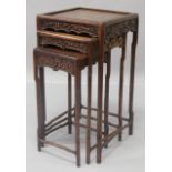 A 19TH CENTURY NEST OF CHINESE ROSEWOOD TABLES, each with a carved frieze on slender legs. Largest