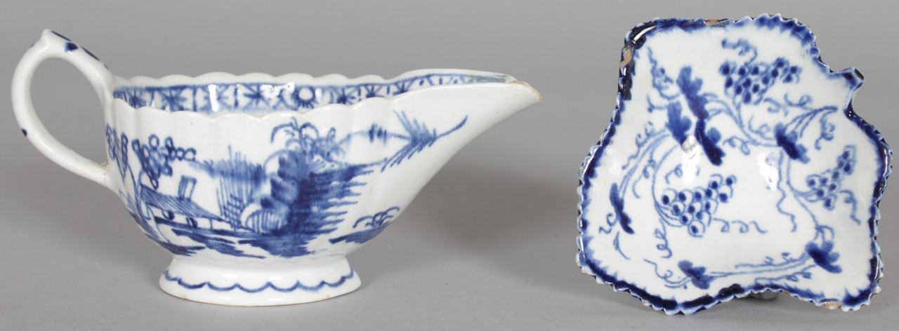 AN 18TH CENTURY BOW CREAMBOAT painted in underglaze blue with trees and a house and a Bow leaf