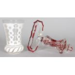 A BOHEMIAN WHITE OPAQUE BEAKER, 5ins high, and a BOHEMIAN BELL PULL, 6.5ins (2).