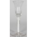 A GEORGIAN WINE GLASS with inverted bell bowl, white opaque twist stem. 6ins high.