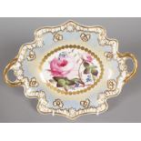 AN OVAL TWO HANDLED DISH, edged in gilt, the centre painted with pink roses. Pattern No. 873, Col