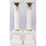 A PAIR OF WHITE MARBLE COLUMNS with square top and pedestal bases. 3ft 4ins high.