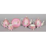 AN UNUSUAL PINK TEA SET, decorated with chariots, comprising teapot and cover, small teapot and