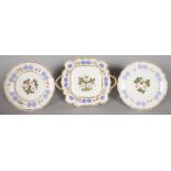 A PAIR OF BOTANICAL CIRCULAR PLATES edged in gilt with blue motifs in relief and a matching two