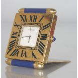 A CARTIER of PARIS QUARTZ TRAVELLING CLOCK with two lapis ends, No. 355116090. 2.5ins, in a red