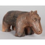 A CARVED TERRACOTTA HIPPO. 8ins long.