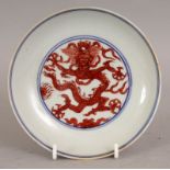 A CHINESE MING STYLE IRON-RED DECORATED PORCELAIN DRAGON DISH, of saucer shape, the base with a