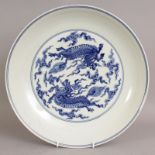 A LARGE CHINESE BLUE & WHITE PORCELAIN DISH, of saucer shape, the interior and the exterior sides