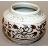 A SMALL MING STYLE COPPER-RED PORCELAIN JARLET, the sides decorated with formal scrolling foliage,