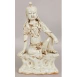 A CHINESE SONG STYLE CELADON PORCELAIN FIGURE OF GUANYIN, seated on a rockwork plinth, 7in wide at