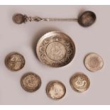 A CHINESE SILVER METAL COIN DISH, 3.1in diameter; five silver-metal coins, each 1.5in diameter;