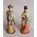 A PAIR OF 20TH CENTURY CHINESE GLAZED CERAMIC FIGURES OF SEATED LADIES, 9.75in & 9.25in high.