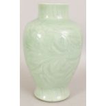 A 19TH CENTURY CHINESE CELADON PORCELAIN VASE, the sides carved underneath the glaze with