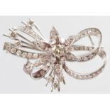 AN 18CT WHITE GOLD AND DIAMOND SET FLORAL AND SCROLL PIERCED BROOCH.