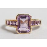 AN AMETHYST RING with amethyst shoulders, set in 9ct yellow gold.