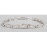 A LOVELY 18CT WHITE GOLD DIAMOND SET FLEXIBLE LINE BRACELET.