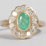 A 9CT YELLOW GOLD, EMERALD AND DIAMOND OVAL CLUSTER RING.