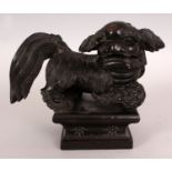 AN EARLY 20TH CENTURY CHINESE CARVED WOOD MODEL OF A BUDDHISTIC LION, standing on a square plinth,