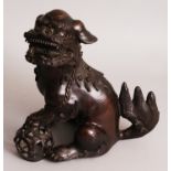 A LARGE 19TH CENTURY CHINESE BRONZE MODEL OF A BUDDHISTIC LION, seated and with one paw resting on a