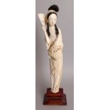 AN EARLY 20TH CENTURY CHINESE CARVED IVORY FIGURE OF A STANDING LADY, together with a fixed wood