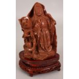 A 20TH CENTURY CHINESE GOLDSTONE CARVING OF GUANYIN, together with a fixed wood stand, the Goddess