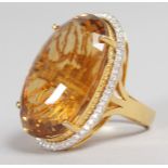 A VERY LARGE IMPRESSIVE CITRINE 40CT RING, surrounded by diamonds in an open mount, in 18ct yellow