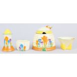 A CLARICE CLIFF CROCUS PATTERN BEEHIVE HONEY POT AND THREE PIECE CRUET (4).