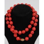 A CINNABAR CARVED BEAD NECKLACE.