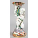 A SUPERB CUPID VASE, as a winged cupid holding a cornucopia vase, on a circular base. 12ins high.