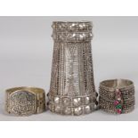 AN ISLAMIC SILVER ARM BAND and TWO BRACELETS (3).