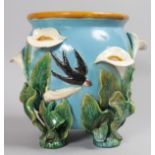 A BLUE MINTON DESIGN MAJOLICA JARDINIERE with lilies and birds in relief. 10ins high.