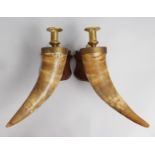 AN UNUSUAL PAIR OF HORN WALL LIGHTS with brass candle holders, on mahogany plaques. 1ft 2ins long.